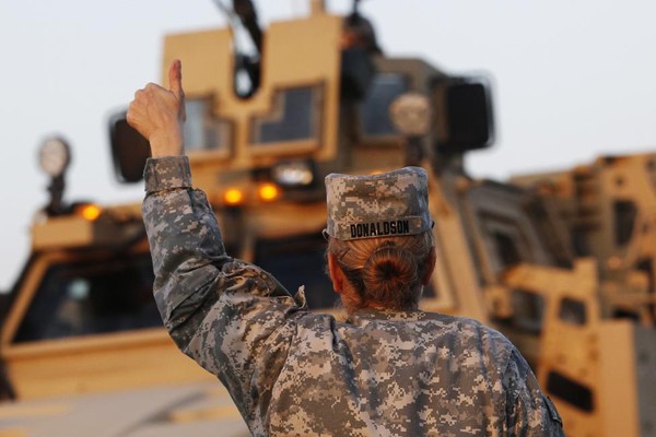 Một nữ chiến binh giơ ngón tay cái cổ vũ đồng đội sau khi tới Kuwait.